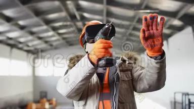 戴着安全帽、穿着工作服的人正站在机库中间，用虚拟现实眼镜钻着机库。